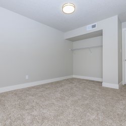 Carpeted primary bedroom with closet at Stone Canyon Apartments, located in Colorado Springs, CO